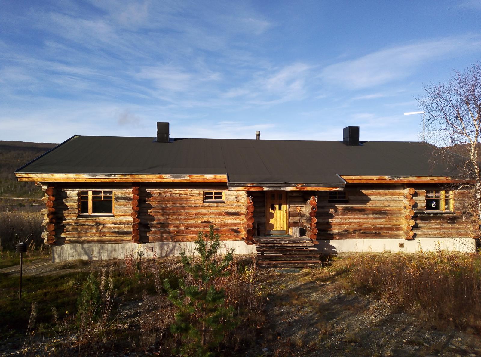 Cabin front facade in autumn sunlight, wide shot
